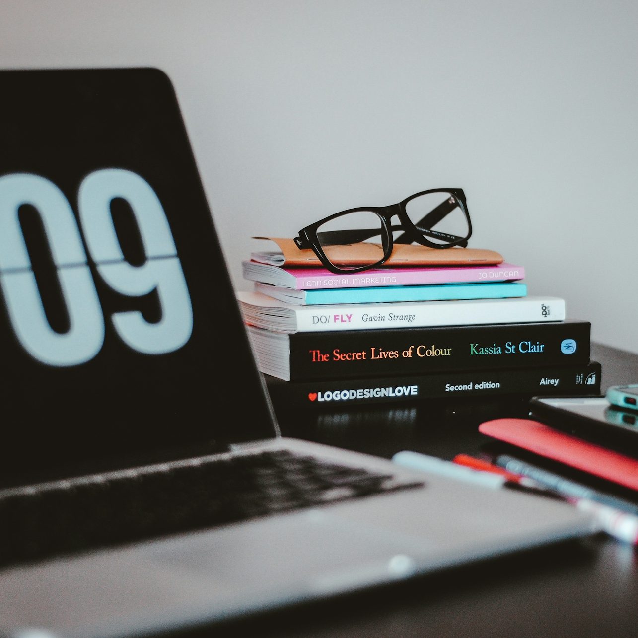 Écran d'ordinateur avec des livres et des lunettes sur un bureau.